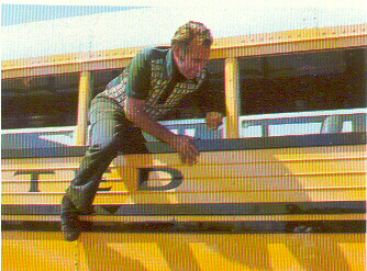 A photo of a man climbing out of a Crown Supercoach's student window.